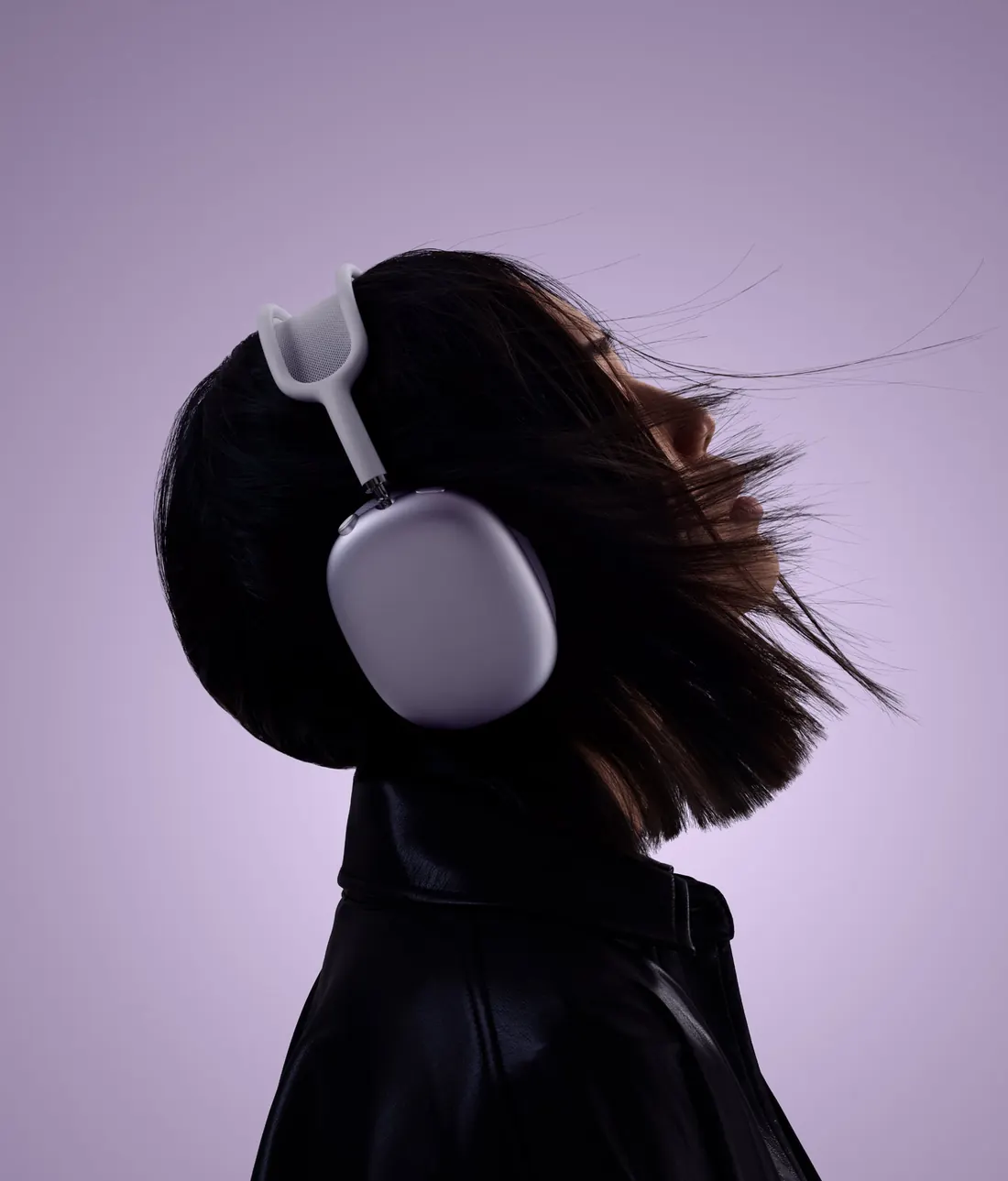 Девушка в AirPods Max 2 фиолетового цвета, волосы развеваются