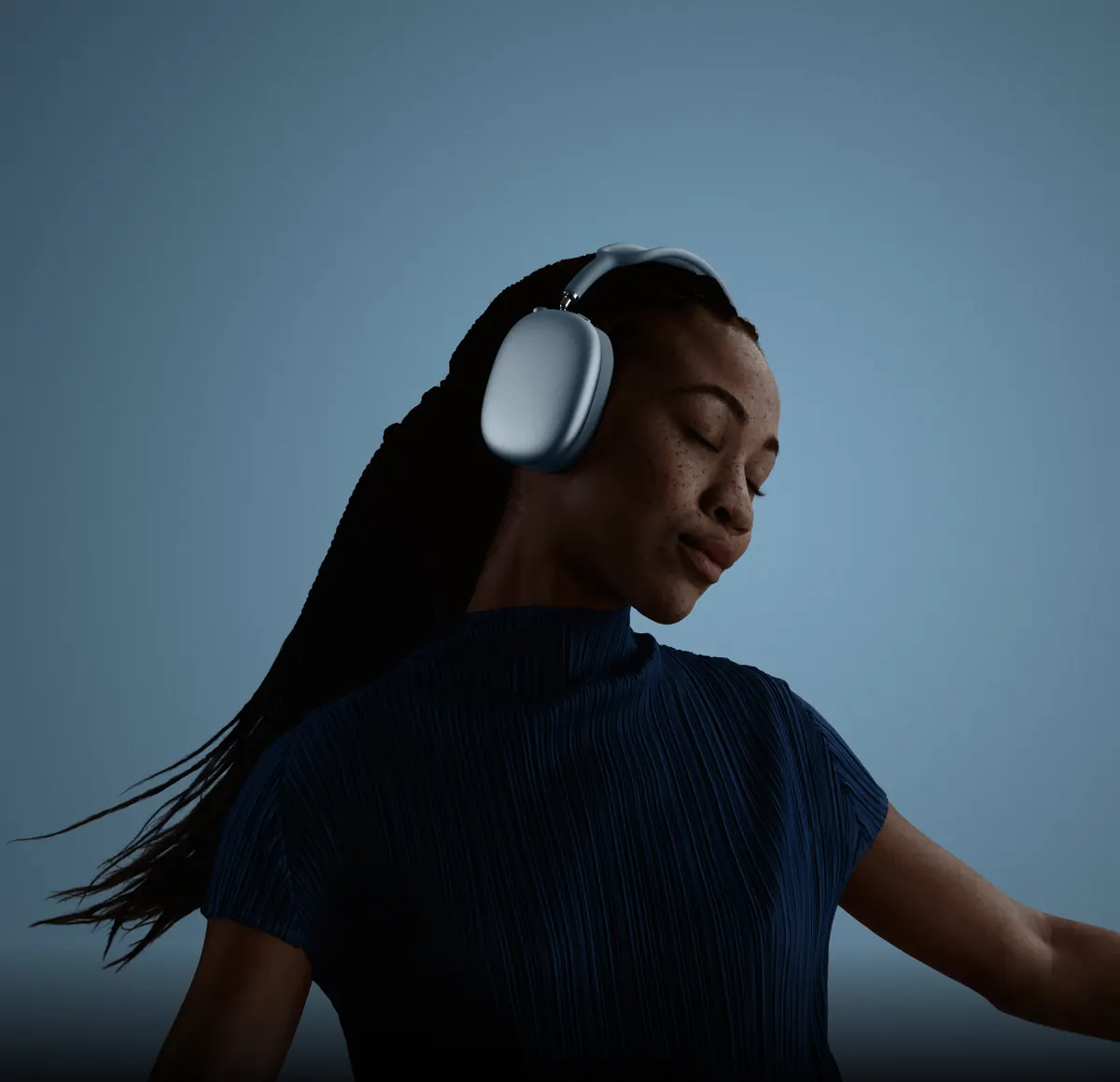 Девушка в AirPods Max 2 синего цвета слушает музыку