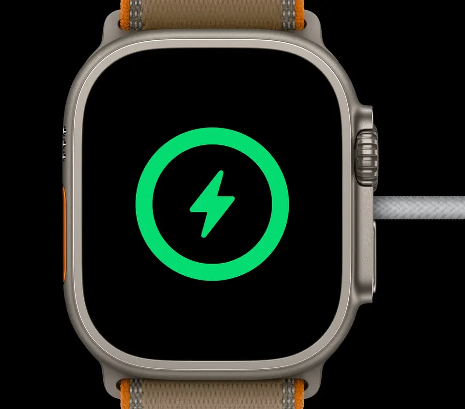 Apple Watch Ultra 4 на магнитной зарядке, на экране — значок зарядки